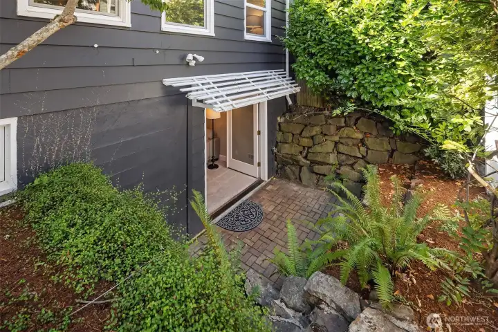 Covered private entrance with patio to lower level.