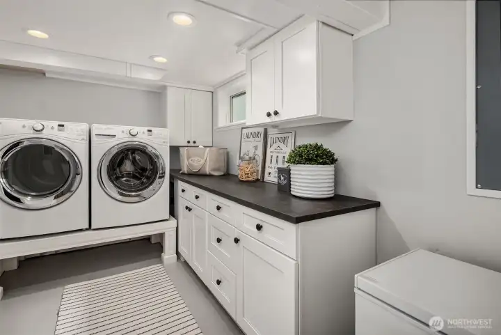 Wonderful laundry room with folding area and abundant cabinet space. Freezer that conveys.
