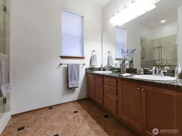 Primary Bath has Granite counter tops. Full Length mirror. Shower with glass doors. Separate Toilet area.  Storage closet for extras also has pullout shelving. Tile Flooring.