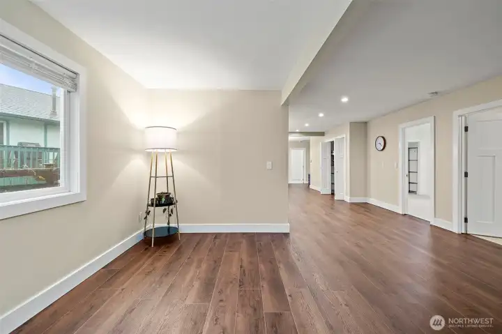 View from the entry into the open and spacious living room. Doors to 2nd bedroom, primary bedroom and storage.