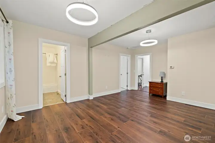 Another view dining room where you can see into the main full bath, 3rd bedroom and far doorway to office/possible 3th bedroom and laundry room. Check out the modern new lighting fixtures!