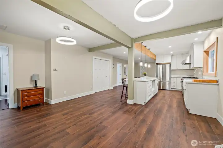 Looking back into the home from the dining room. Gleaming LVP flooring, great paint accents and beams! Such style and comfort!