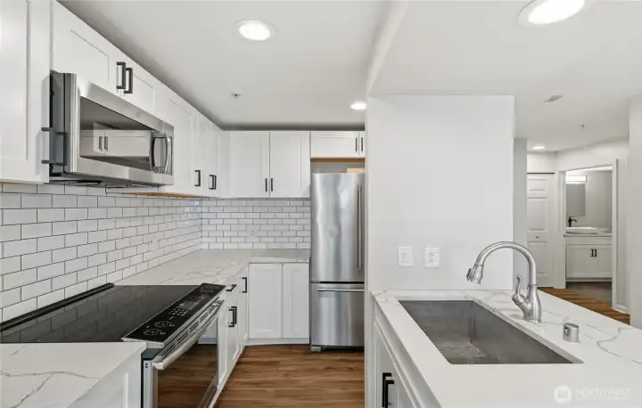 Updated kitchen with stainless steel appliances and quartz countertop.