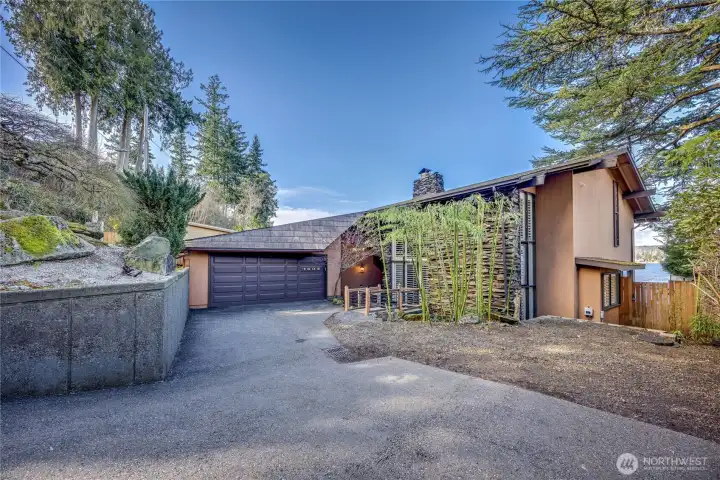 A striking bridge-style entry crosses the serene koi pond, creating a memorable approach to the home.