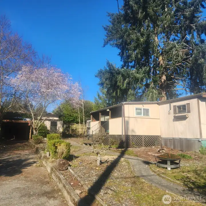 Garage with wood stove and carport on left