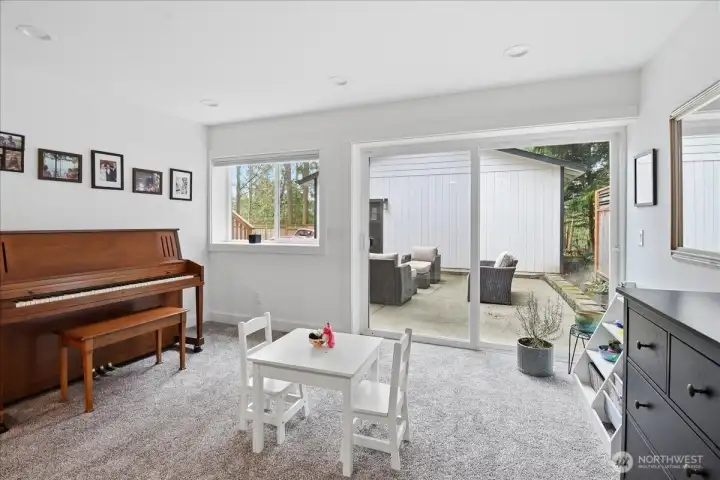 Downstairs gathering space with view out to the paved patio.
