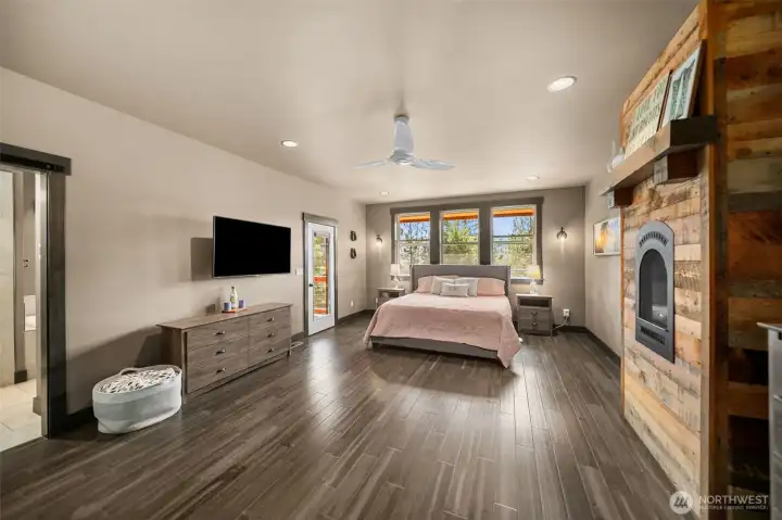 The main-level primary suite offers a private fireplace, spa-like bath with jetted tub, walk-in closet, and direct deck access with hot tub for ultimate relaxation.