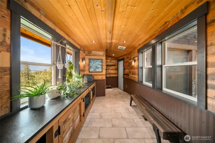 An oversized mudroom with built-in dog kennels & pet washing station adds everyday functionality