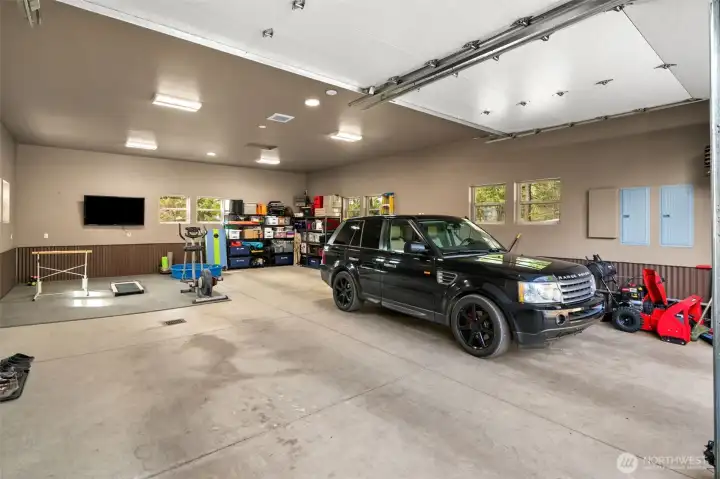 4-car garage (25x40) with 10’ doors, heated, wired for EV charger, hot/cold water, work space and tons of storage space