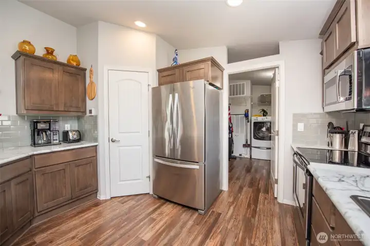 Pantry on left and laundry on right side of refrigerator
