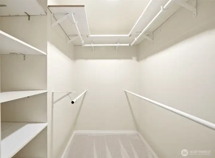 Spacious primary walk-in closet with built-in shelving and plenty of room for storage and organization Spacious primary walk-in closet with built-in shelving and plenty of room for storage and organization