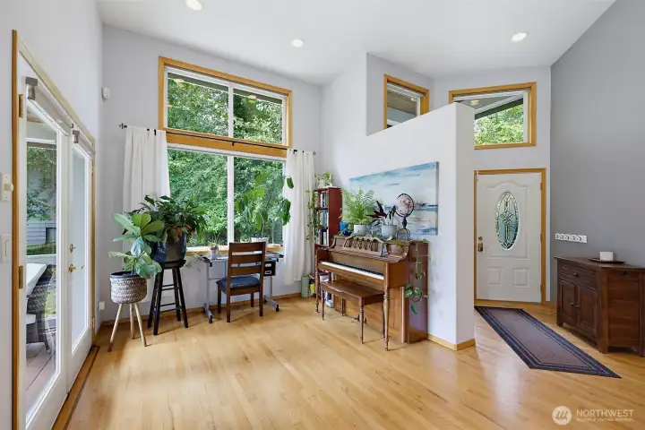 Just off the entry this vaulted ceiling sitting area is filled with so many windows for natural light! Sunlight gleams off the hardwood floors as you come through the front door.  The French doors lead to a nice wrap around deck.