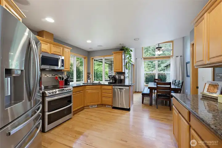 Bright and inviting, the kitchen is filled with natural light from an abundance of windows, creating the perfect space for everyday living and entertaining.  The attached dining area offers seamless access through a sliding glass door to the spacious deck, making outdoor barbecues effortless.
