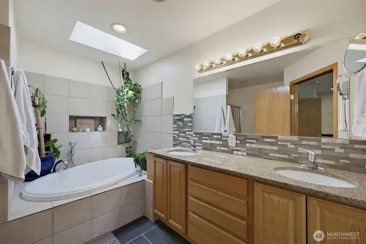 Primary 5 piece bathroom boast a double vanity with granite countertops & tile backsplash, heated floors, bidet with heated water, skylight adds extra lighting, deep soaking tub & walk-in shower.