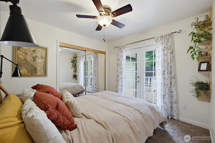 Bedroom #2 with new carpeting and French doors that lead to a side deck overlooking the yard.