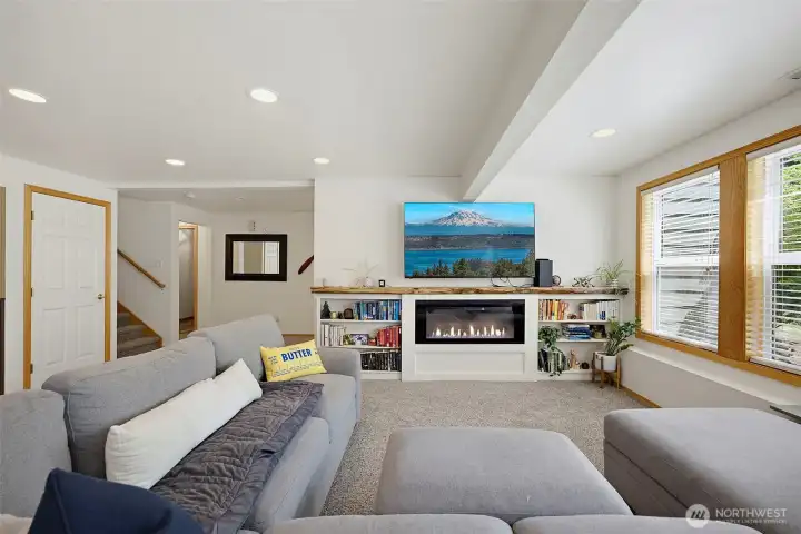 Lower level bonus room with built ins, electric fireplace & custom live edge mantle.