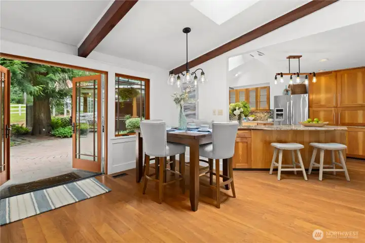 Informal dining area by the rear French doors open up to the patio and pastures beyond. The barn is up the hill to the right.