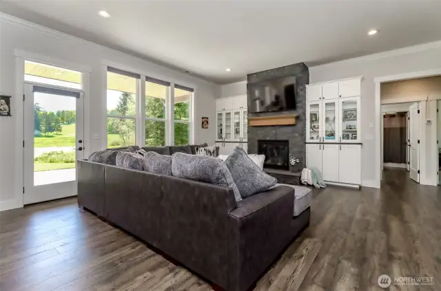 Living room with gorgeous built in cabinetry, stone fireplace and view windows.