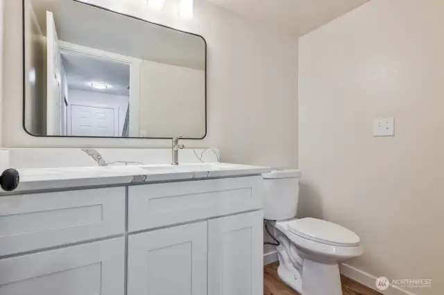 Half bathroom located on main level. New vanity, toilet and mirror