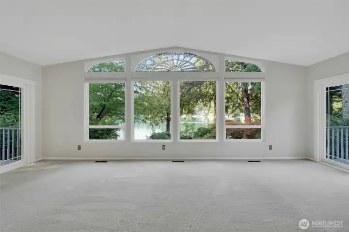 Living room with lots of natural light from windows and 2 slider doors