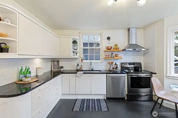 The kitchen has been updated with granite counters, subway tile backsplash, new lighting, floating shelves and 12 X 24 gray tile flooring giving it a transitional feel.