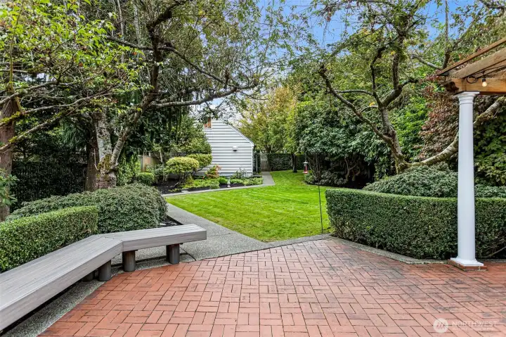 This lovely backyard features an expansive patio and built-in bench, super private.