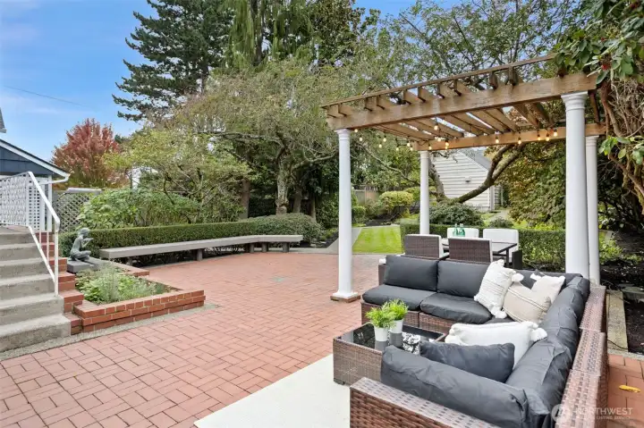Backyard patio facing bench and rear entry of home.