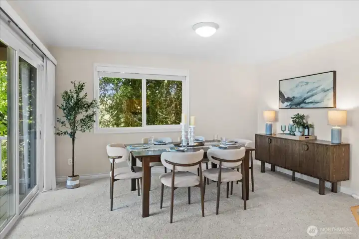 The liiving area flows to the diniing room, featuring an oversized sliding glass door, opening to the wrap-around deck.