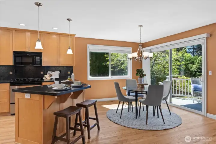 This bright kitchen features a breakfast bar, recessed lighting, and a spacious casual dining area that opens to the wrap-around deck and sound and mountain views.