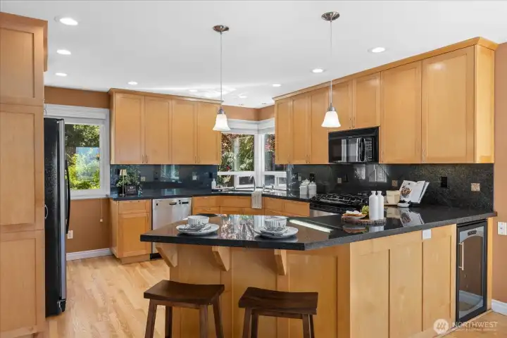 The well-appointed kitchen boasts sleek granite countertops, high-end stainless steel appliances, wine fridge and tons of custom cabinetry for storage.