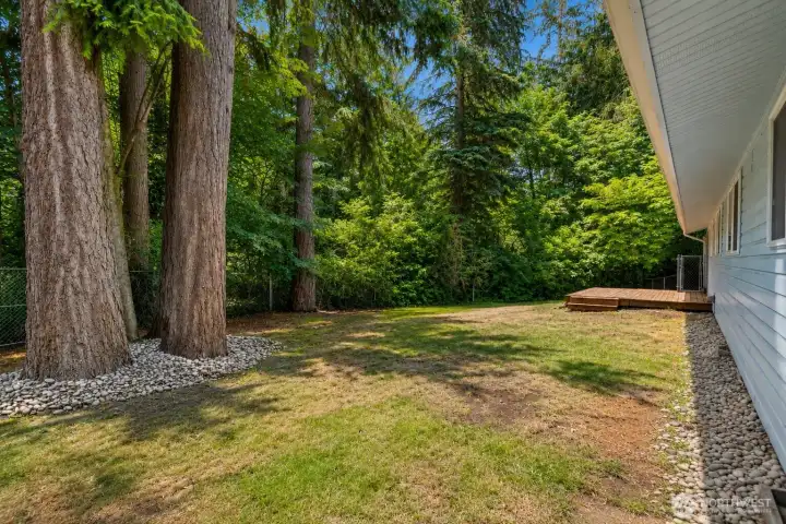 Distant view of your great deck and abundantly private yard.