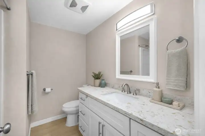 Seamless flow - your guest bathroom carries the same new, beautiful quartz countertops and cabinets from the kitchen with updated lighting and flooring.