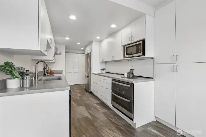 Wall of cabinetry to right.  Deep cabinetry for larger pots, pans and plates.