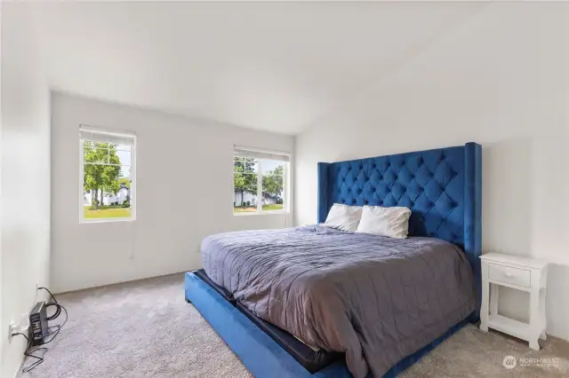 VIEW OF LARGE PRIMARY BEDROOM WITH VAULTED CEILINGS AND ROOM FOR OUR YOUR STYLISH BEDROOM DECOR.  EVEN MORE VIEWS OF YOUR WATERFRONT TO ENJOY FROM WINDOWS