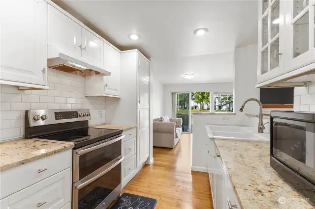 Luxurious new updated modern kitchen with newer ss appliances tile backsplash garden sink, BAMBOO hardwoods on main level,lot of white stylish cabinets and slab granite counters to enjoy when you live here