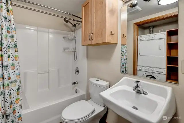 Functional bathroom with a dual-function toilet, a practical shower/bath combo, and a no-fuss sink—perfectly designed for everyday efficiency.