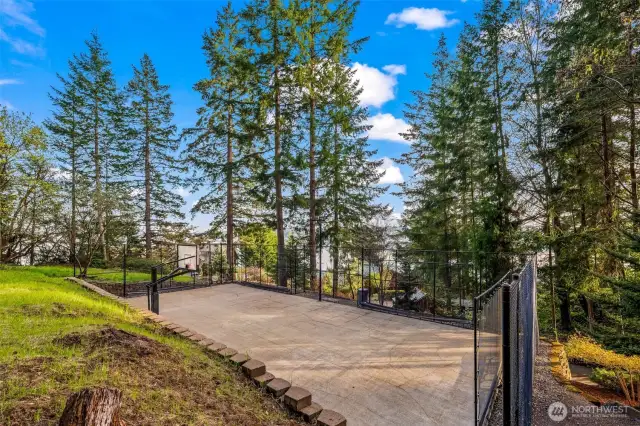 Full-sized tennis court with baskeball hoop.  It's totally enclosed.  Come put up the nets and play tennis or pickleball.  Fun for the whole family or invite your friends over!