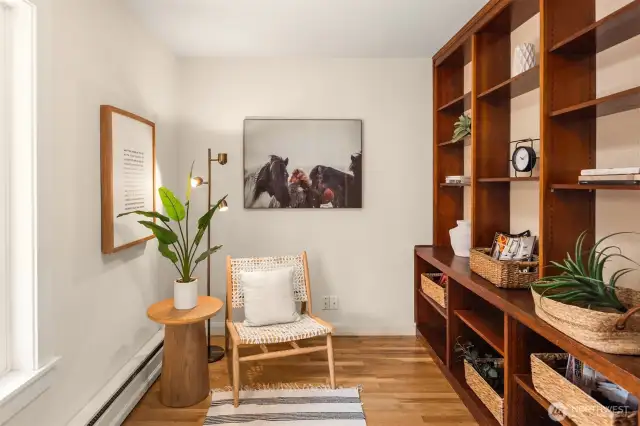Charming main-level office with built-ins, warm wood tones, and garden/barn views.