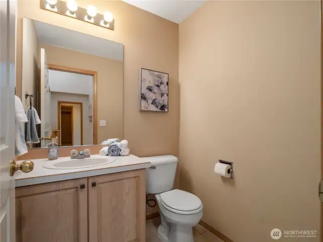 The first-floor half bath can be found off the hallway to the kitchen and main living spaces.
