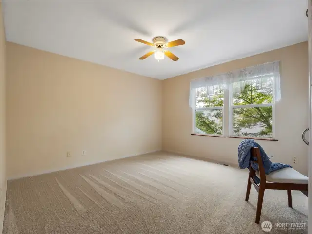 This bedroom features a wall of built-ins with a desk area.