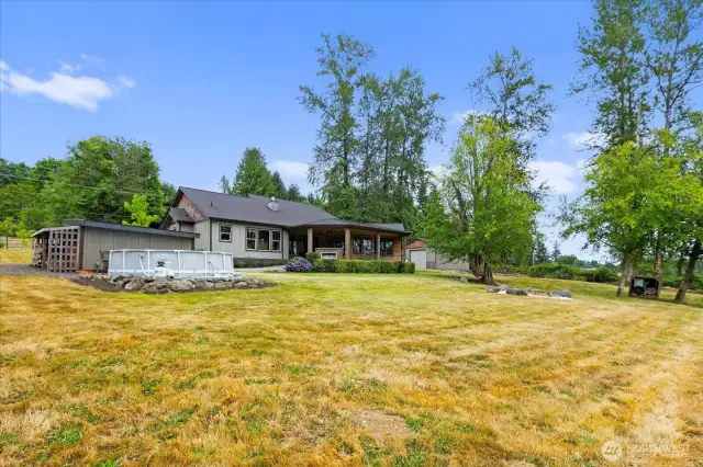 View from the back corner of the property. Above ground pool, fire pit and storage shed!