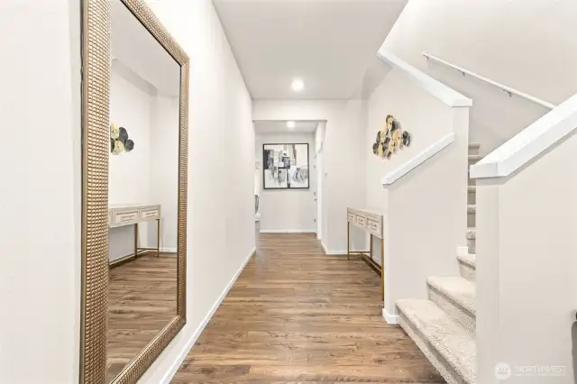 Step into a bright and welcoming entryway with rich wood-look flooring, modern accents, and an open flow that sets the tone for the rest of this beautifully maintained home.