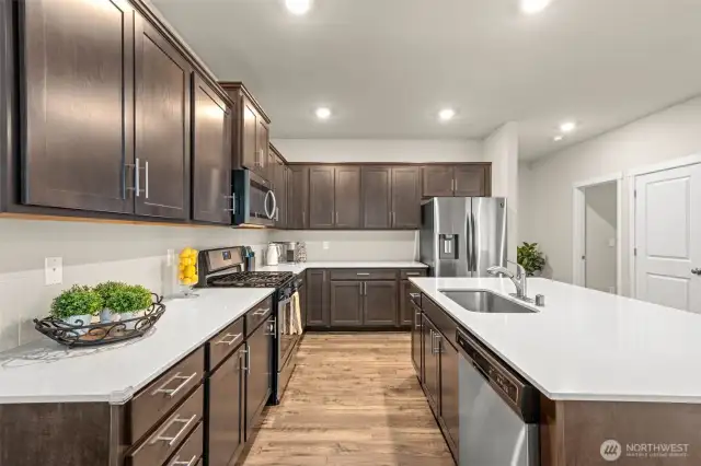 Showcasing abundant cabinetry, generous counter space, and a central island with built-in sink, this kitchen is designed for both style and practicality