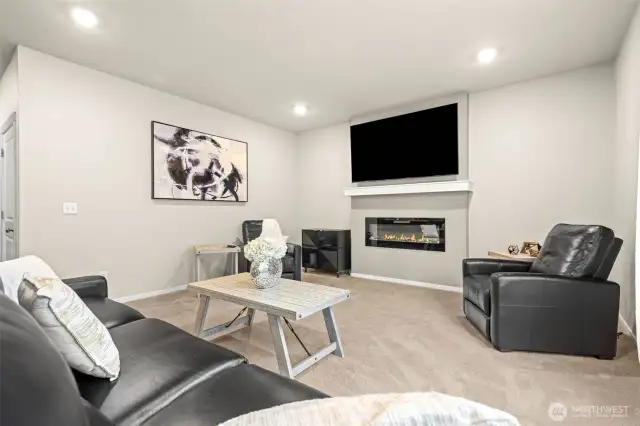 Bright and spacious great room centered around a statement fireplace and ready for movie nights or casual gatherings with family and friends.