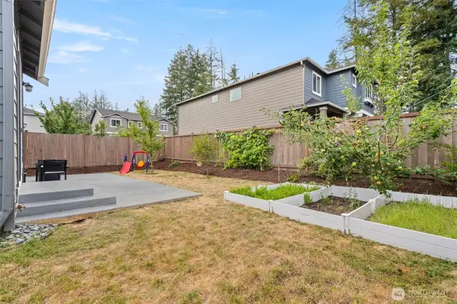 Enjoy the fully fenced backyard complete with a spacious patio, fruit trees, raised garden beds, and room to play or entertain year-round