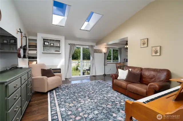 From the entry there is a light filled living room with vaulted ceiling, skylights and gas fireplace!