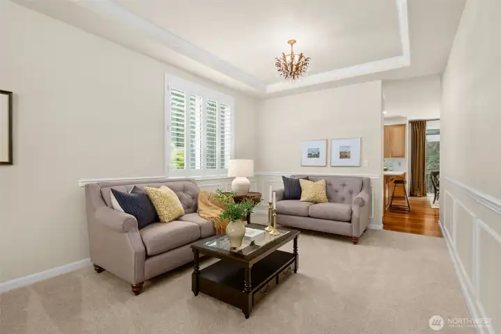 The formal dining/living room off the kitchen is spacious and features a trayed ceiling.
