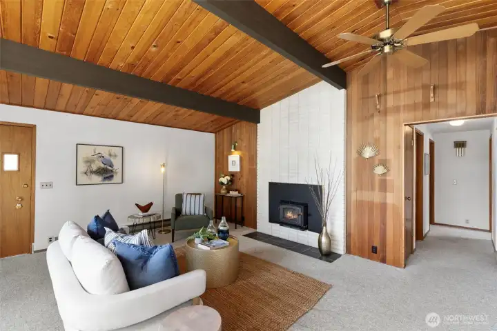 Wood burning fireplace insert with white brick surround is not only functional is an attractive feature. Oversized ceiling fan and vaulted ceilings.
