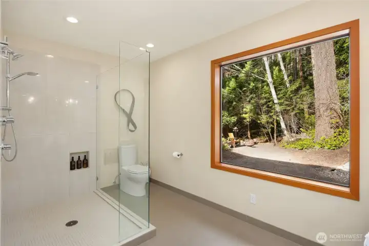 The primary bathroom enjoys nature views of the surrounding property and tranquil fountain.