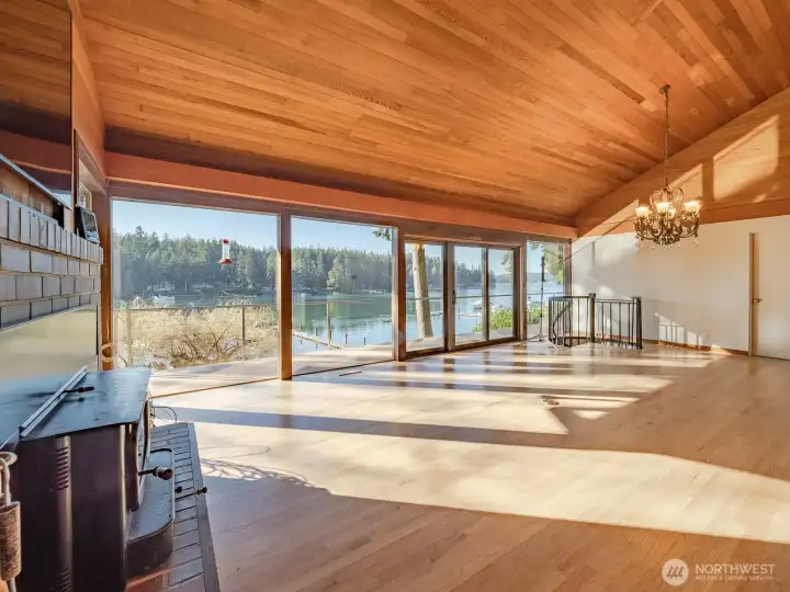 Great room with a wall of windows showcasing this amazing waterfront residence